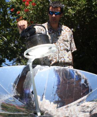 SunFire's solar energy expert, Zander van Manen, cooking on a parabolic solar dish, Johannesburg, South Africa. (Photo by Darren Taylor of VOA)