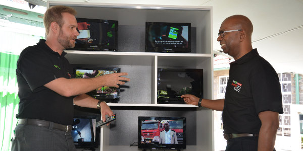 M-KOPA Solar CEO Jesse Moore explains the features of the M-KOPA solar powered digital flat screen TV to Safaricom CEO Bob Collymore. The solar powered TV that has been launched today will be accessible to both old and new M-KOPA customers.